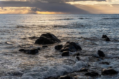 Rocks on the beach of Playa del Inglés. Sunset. Sea and waves. Valle Gran Rey, La Gomera, Canary