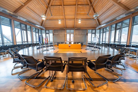 Inviting conference room with round wooden table and stylish furnishings for formal meetings,