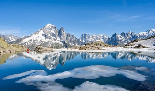 Mountain landscape with mountain lake and ice floe, water reflection in Lac Blanc, mountain peak,