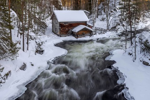 Old wooden Myllykoski water mill along the river Kitkajoki in winter, Oulanka National Park,