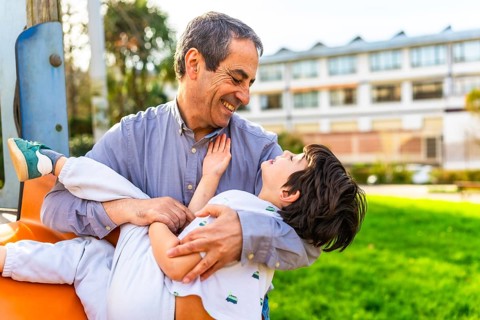 Grandfather and grandson enjoying playful moments together at the park, sharing laughter and