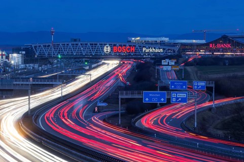 A8 motorway at Stuttgart Airport in the evening. Heavy traffic, lanes of light. Modern architecture