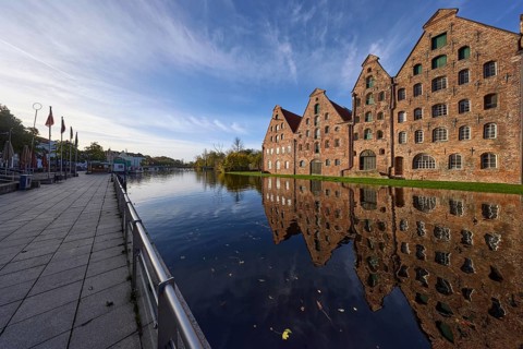 Historic salt warehouses, brick buildings reflected in the morning light on the water surface of