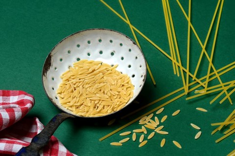 Semi di orzo in sieve ladle, pasta variety in the form of cereal grains and spaghetti