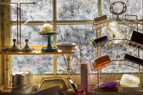 Assorted curios for sale on shelves in front of window inside second hand goods and chattels store,