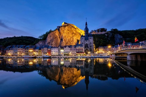 Night view of Dinant town, Collegiate Church of Notre Dame de Dinant over River Meuse and Pont