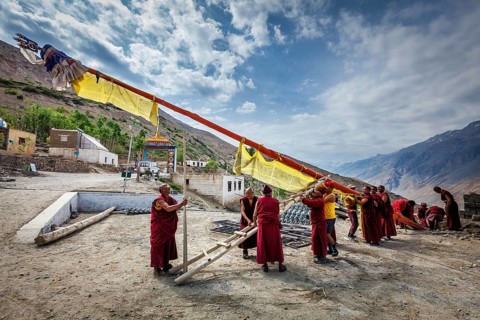 DHANKAR, INDIA, JULY 2, 2012: Tibetan Buddhist monks of Dhankar gompa setting up the pole with