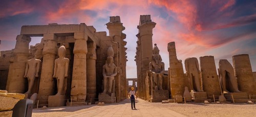 Sculptures of ancient Egyptian pharaohs and drawings on the columns of the Luxor Temple in the