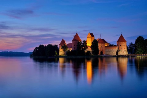 Night view of Trakai Island Castle in lake Galve illuminated in the evening, Lithuania, Europe
