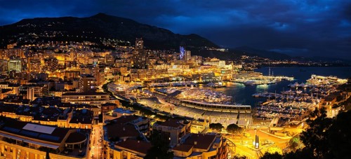 Aerial panorama of Monaco Monte Carlo harbour and illuminated city skyline in the evening blue hour