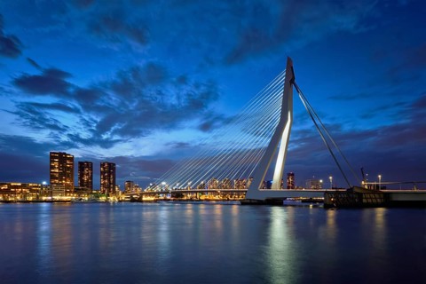Erasmus Bridge (Erasmusbrug) and Rotterdam skyline illuminated at night. Rotterdam, Netherlands