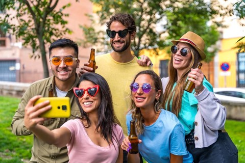 Multi ethnic group of friends partying in the city park taking a selfie, friendship and fun concept