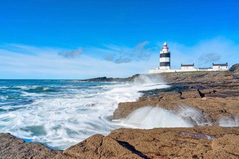 Hook Head lighthouse, blue sky and spray, Wexford, Ireland, Europe
