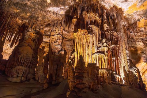 Interior of caves of drach illuminated by colorful lights showing stalactites and stalagmites in