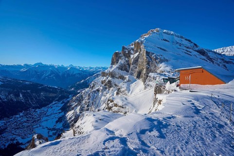 Snow-covered mountain landscape under a clear blue sky, mountain station, Gemmi cable car, Gemmi