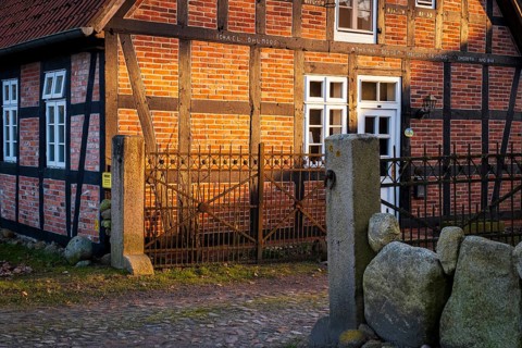Evening light shines on a driveway and the façade of a half-timbered house, Otersen, Kirchlinteln,