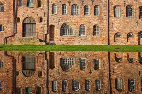 Salt warehouse, historic brick buildings, reflections on the water surface of the Trave, Hanseatic
