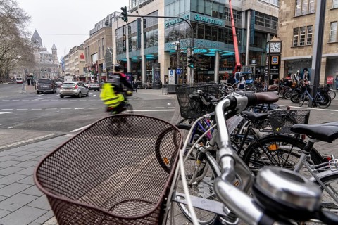 Cycling in the city centre, here at Neumarkt in Cologne, parked bikes and e-scooters at the