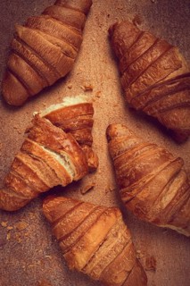 Fresh croissants, breakfast, top view, on the table, brown background, no people