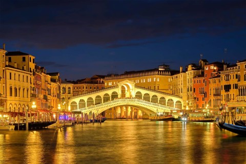 Famous Venetian tourist landmark Rialto bridge (Ponte di Rialto) over Grand Canal with vaporetto