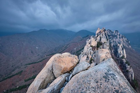 View of stones and rock formations from Ulsanbawi rock peak in stormy weather with clouds.