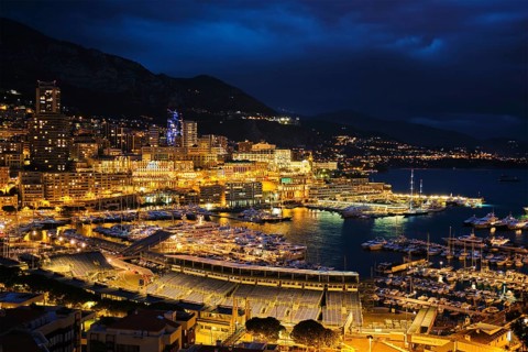 Aerial view of Monaco Monte Carlo harbour and illuminated city skyline in the evening blue hour