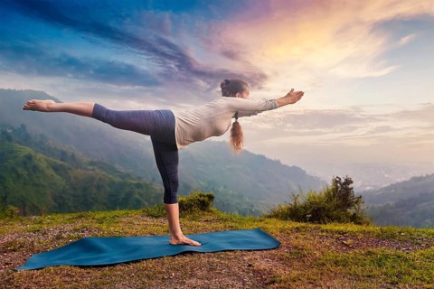 Yoga outdoors, sporty fit woman doing Ashtanga Vinyasa Yoga asana Virabhadrasana 3 Warrior pose