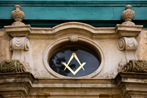 Close-up with compass and angle, two of the best-known symbols of Freemasonry on the lodge house,