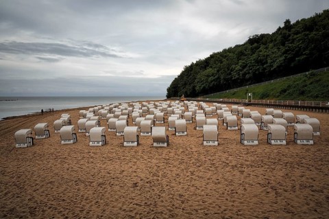 Rainy weather at the Baltic Sea, empty beach chairs, single walkers, view from above, long