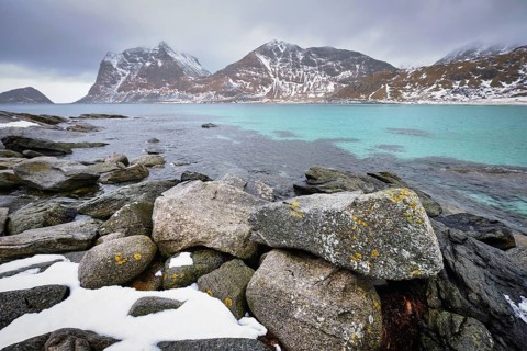 Rocky coast of fjord of Norwegian sea in winter with snow. Haukland beach, Lofoten islands, Norway,