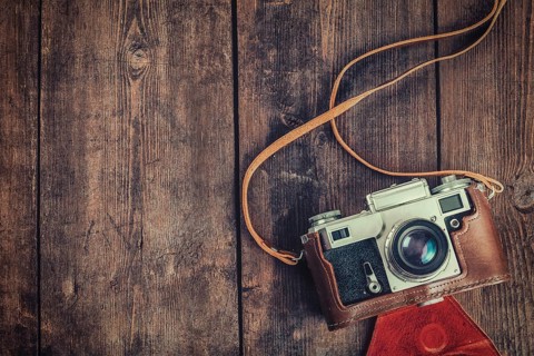 Photography concept background, old retro vintage camera on grunge wooden texture