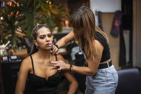 Halloween party hairstyle and makeup preparations, make-up artist making up a woman