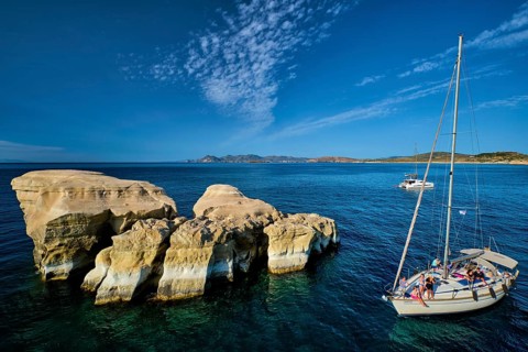 Sarakiniko, Greece, May 23, 2019: Yacht boat with tourists passing near white rocks of famous