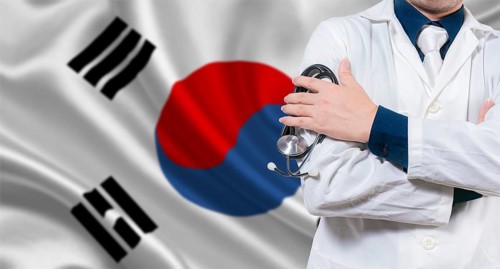Doctor with stethoscope on South Korean flag. Doctor with crossed arms on South Korean flag.