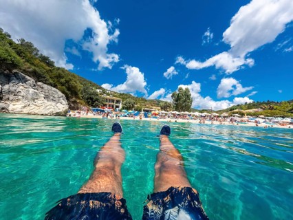 A man resting in the sea on the beach in summer of Paralia Mikros Gialos in the south of the island