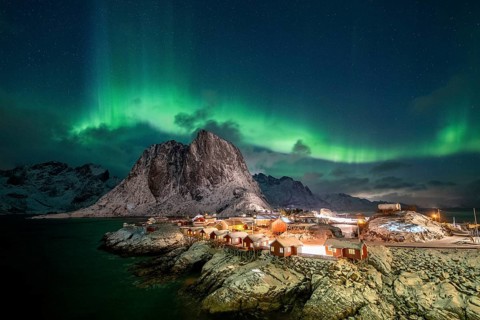 Northern Lights (Aurora Borealis) over Rorbuer Huts of Hamnoy, snowy mountains behind, Hamnøy,