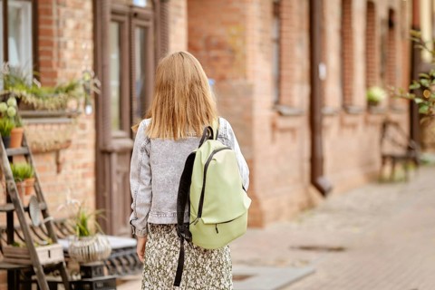 Cute tourist woman in old town, back view