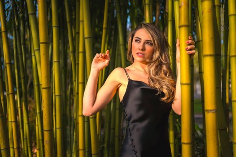 Portrait of a Caucasian girl in a black dress in a bamboo forest