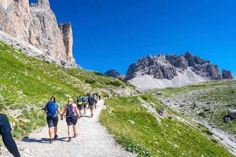 Tourists enjoying a scenic hike on the tre cime di lavaredo trail amidst the breathtaking mountain