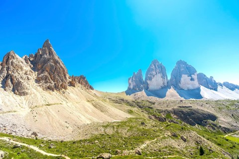 Panoramic view of the tre cime di lavaredo with hikers enjoying the sunny summer day in the italian
