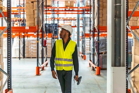 Horizontal photo with copy space of an african man with reflective clothes and helmet walking in a