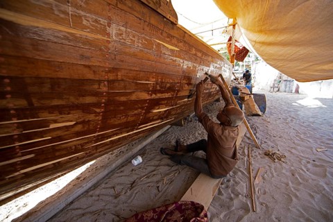 Indian man working at a dhow shipyard in Sur, Janub ash-Sharqiyya province, Oman, Asia
