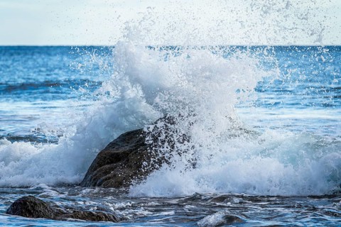 Rocks and sea on the beach of Playa del Inglés. Splashing spray from a wave. Valle Gran Rey, La