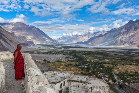 DISKIT, INDIA, SEPTEMBER 12, 2012: Unidentified Tibetan Buddhist monk praying on roof of Diskit
