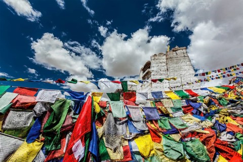 Ruins of Victory Fort Tsemo on the cliff of Namgyal hill and colorful Buddhist prayer flags with
