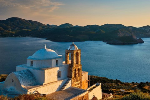 Traditional whitewashed Greek Orthodox church in Plaka village on Milos island on sunset. Milos