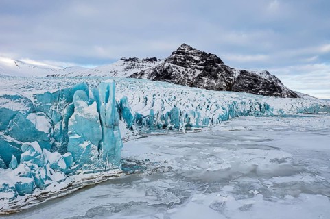 Glacier break-off and snow-covered icebergs in the Fjallsarlon glacier lagoon, with the