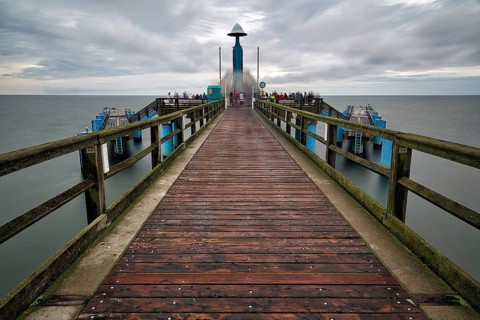 Sellin pier with tourists in front of diving gondola, rainy weather on the Baltic Sea, long