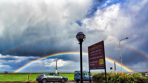 View of the coast road from the Strand Hotel, double rainbow in the cloudy sky, Bray, Wicklow,