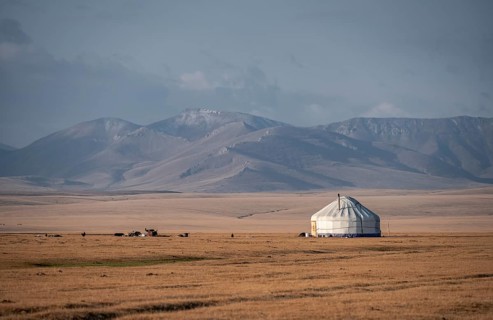 Traditional yurts at Songköl on a plateau, mountains in the background, Kyrgyzstan, Asia